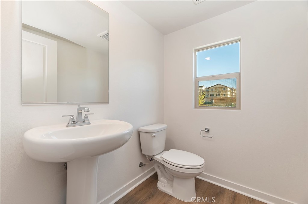 3975 Lavine Way Corona, CA 92883 - Photo 9 of 24 a bathroom with a toilet sink and mirror