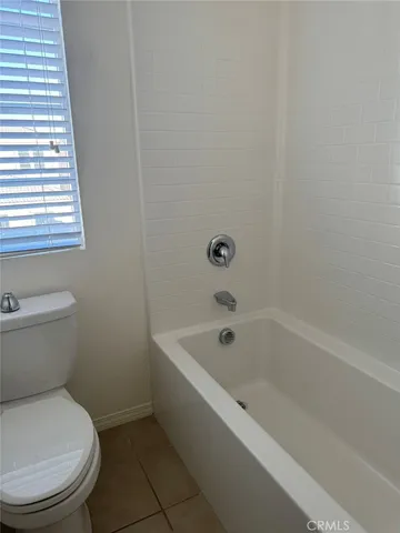 a white toilet sitting next to a bath tub