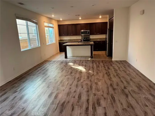 a view of kitchen with microwave a stove and wooden floor