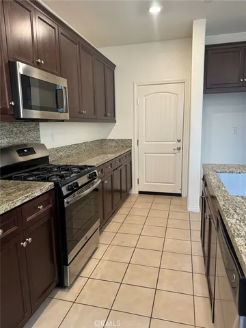 a kitchen with a stove a microwave and wooden cabinets