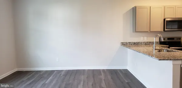 a kitchen with a sink a microwave and cabinets
