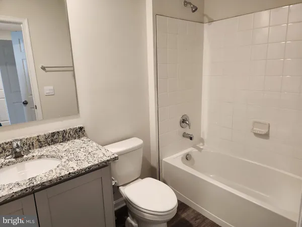 a bathroom with a granite countertop sink toilet and bathtub