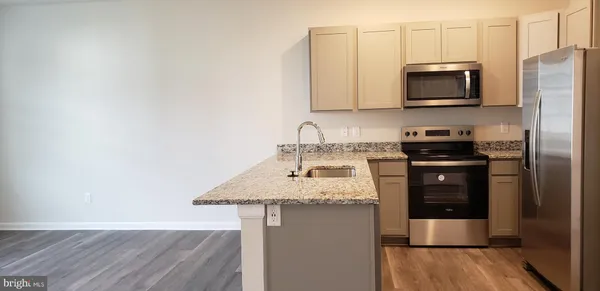 a kitchen with stainless steel appliances granite countertop a stove a microwave and a refrigerator