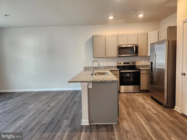 a kitchen with stainless steel appliances a sink stove refrigerator and microwave