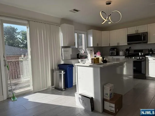 a kitchen with a refrigerator a stove cabinets and a dining table