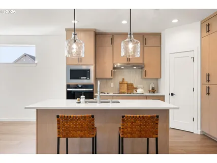 a kitchen with kitchen island granite countertop a sink cabinets and stainless steel appliances