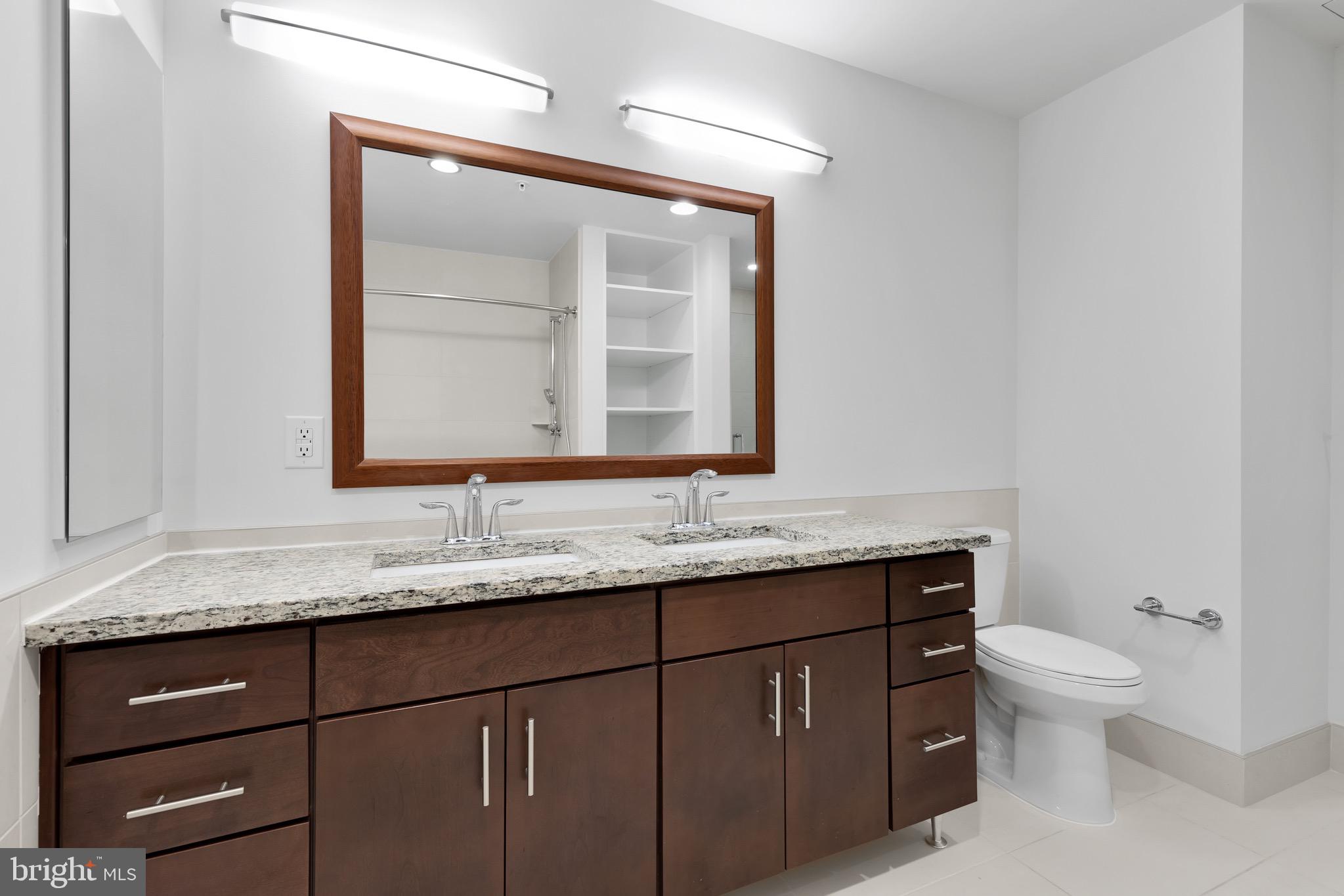 880 New Jersey Avenue Southeast, Unit 1 BR Washington, DC 20003 - Photo 12 of 28 a bathroom with a granite countertop toilet sink and mirror