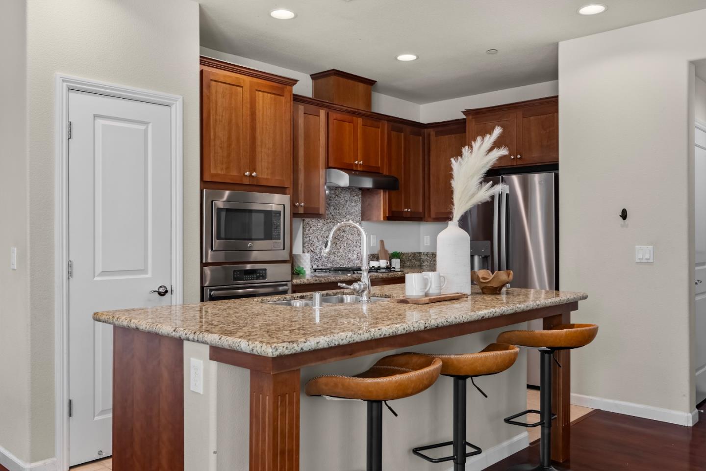 719 Raines Terrace Sunnyvale, CA 94087 - Photo 11 of 47 a kitchen with granite countertop a sink and a refrigerator