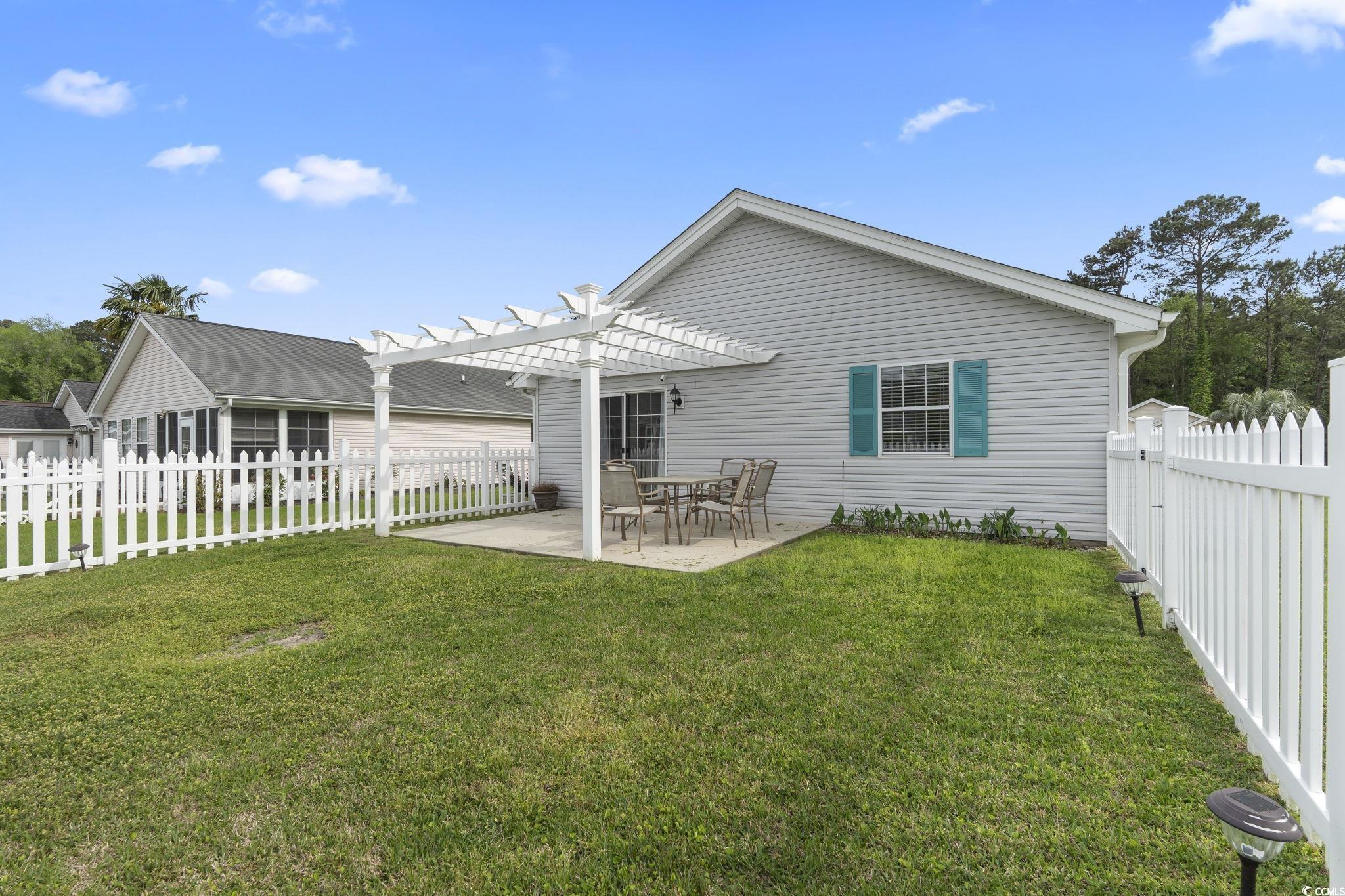 1130 Ganton Way Myrtle Beach, SC 29588 - Photo 22 of 30 Back of property with a patio, a pergola, a fenced backyard, and a lawn