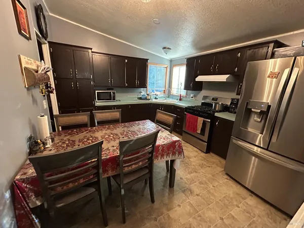 a kitchen with stainless steel appliances granite countertop a refrigerator stove microwave and sink