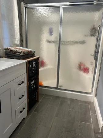 a bathroom with a granite countertop sink a mirror and shower