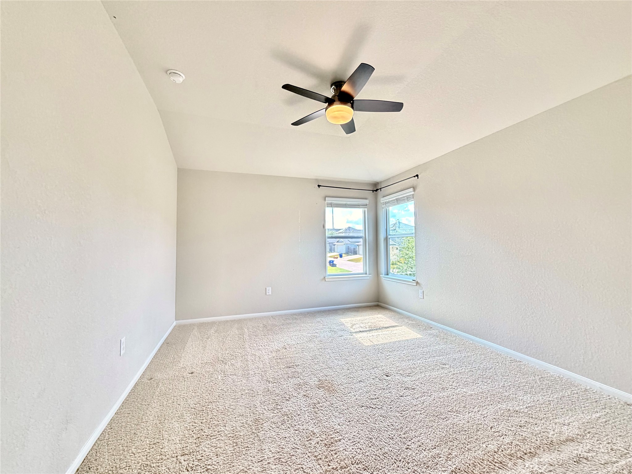 10502 Fulton Avenue Austin, TX 78754 - Photo 16 of 36 A well-lit bedroom features plush carpeting and a modern ceiling fan, ready for personal touches.