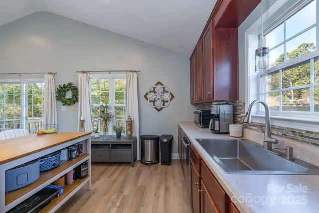 a kitchen with stainless steel appliances granite countertop a sink a stove and a wooden floor