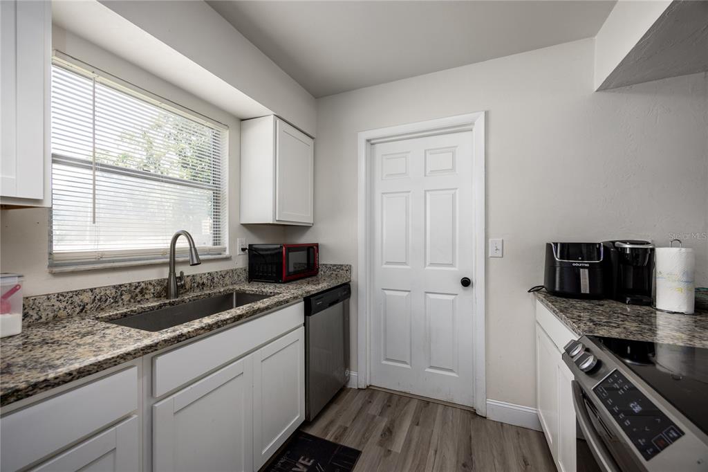 15872 Southwest 133rd Lane Archer, FL 32618 - Photo 20 of 28 a kitchen with granite countertop stainless steel appliances a sink stove and cabinets