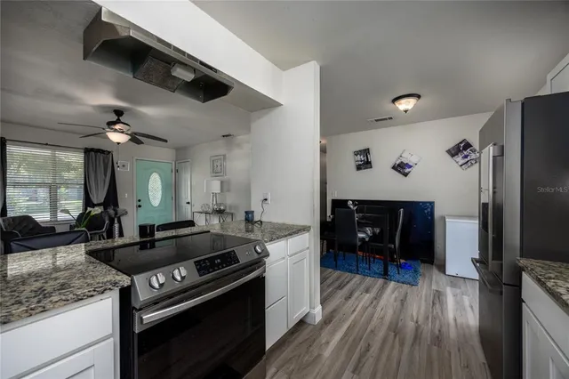 a kitchen with granite countertop a stove and a refrigerator