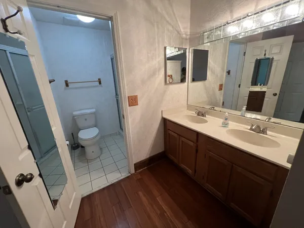 a bathroom with a double vanity sink and mirror with shower