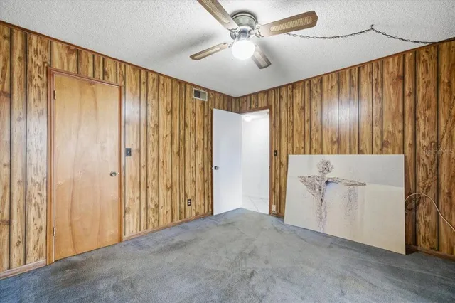 an empty room with windows and fan