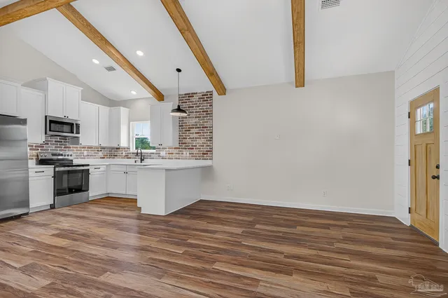 a kitchen with a sink cabinets stainless steel appliances and a window