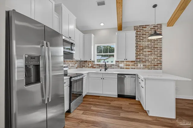 a kitchen with white cabinets and stainless steel appliances