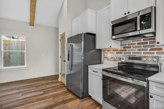 a kitchen with wooden cabinets and stainless steel appliances