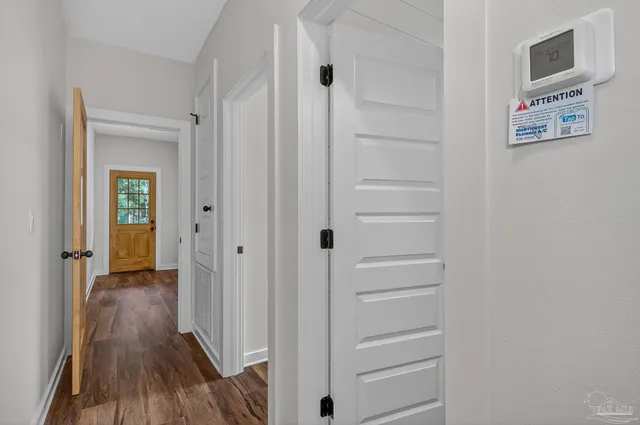 a view of a hallway with wooden floor and closet