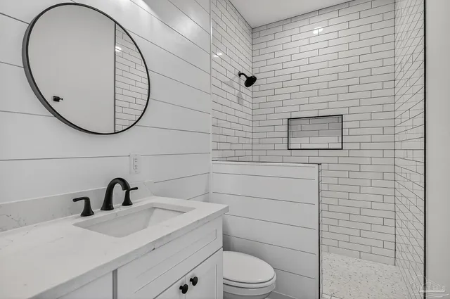 a bathroom with a sink a toilet and a mirror