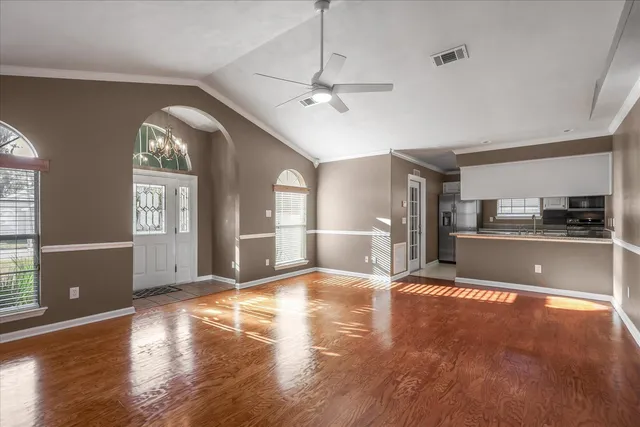 a view of a kitchen with wooden floor and a window