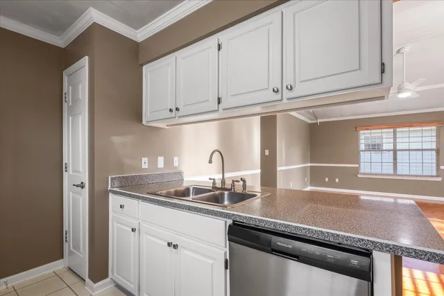 a kitchen with granite countertop white cabinets and a sink