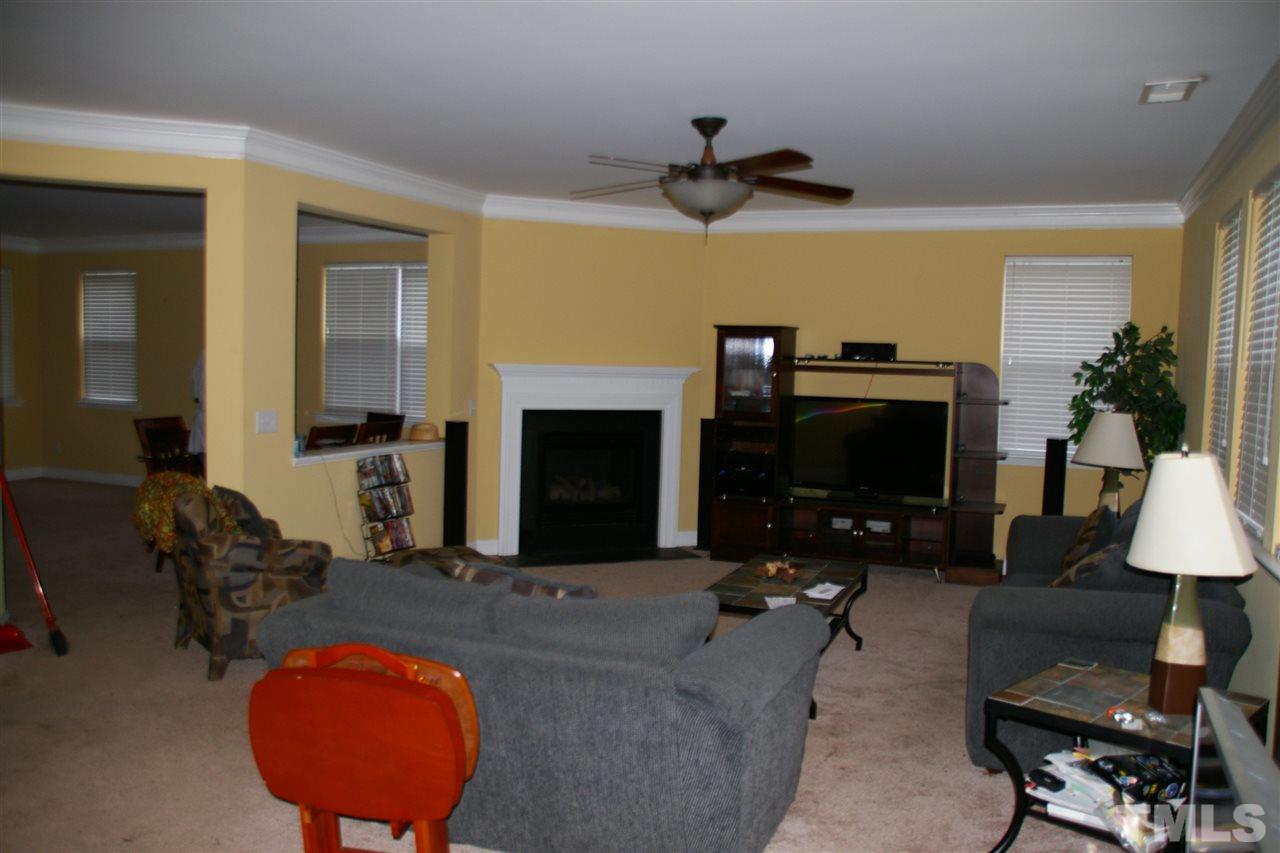 5245 Thornton Road Raleigh, NC 27616 - Photo 4 of 9 a living room with furniture a fireplace and a flat screen tv
