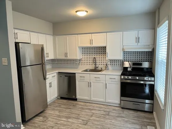 a kitchen with white cabinets and stainless steel appliances