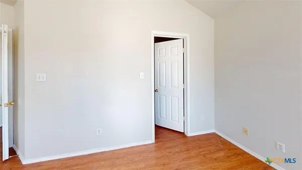 a view of an empty room with wooden floor