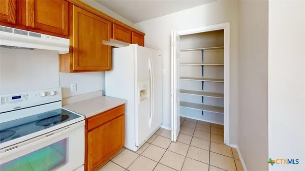 a kitchen with a refrigerator and a stove top oven