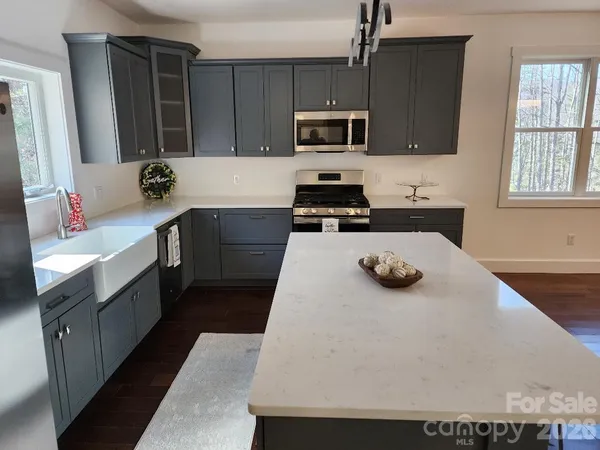 a kitchen with stainless steel appliances granite countertop a refrigerator a sink a stove and cabinets