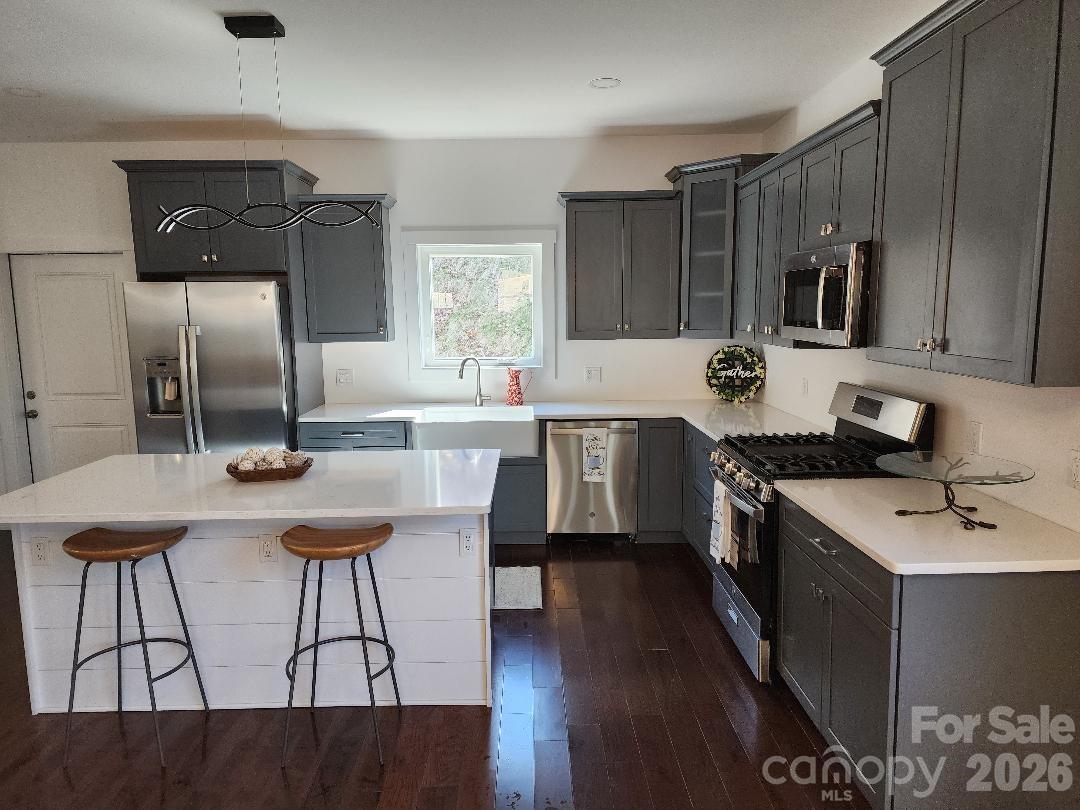 24 Salt Burnsville, NC 28714 - Photo 14 of 42 a kitchen with stainless steel appliances kitchen island granite countertop a sink cabinets and wooden floor