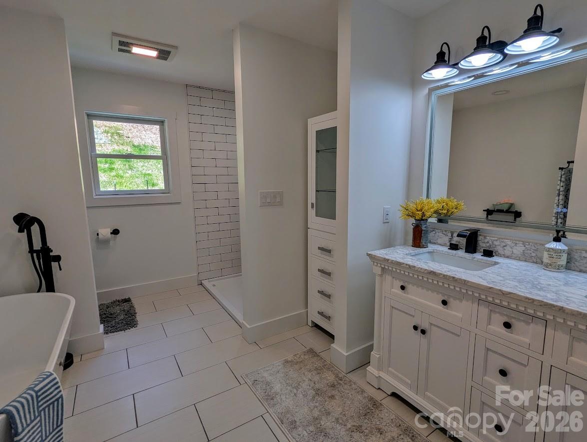 24 Salt Burnsville, NC 28714 - Photo 38 of 42 a spacious bathroom with a double vanity sink a mirror and a bathtub
