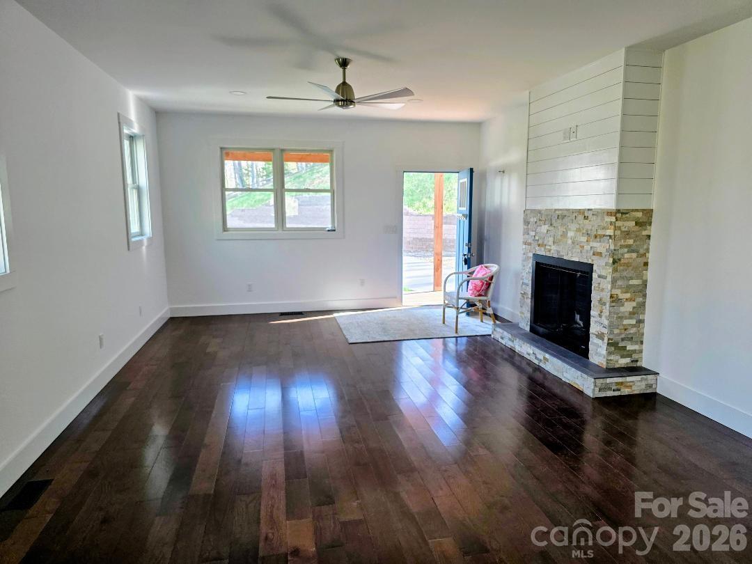 24 Salt Burnsville, NC 28714 - Photo 9 of 42 an empty room with wooden floor fireplace and windows