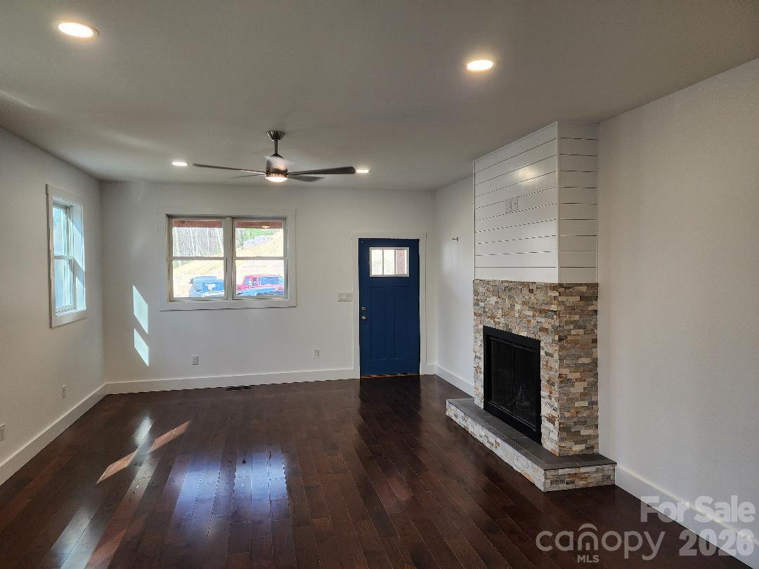 24 Salt Burnsville, NC 28714 - Photo 10 of 42 an empty room with wooden floor a fireplace and windows