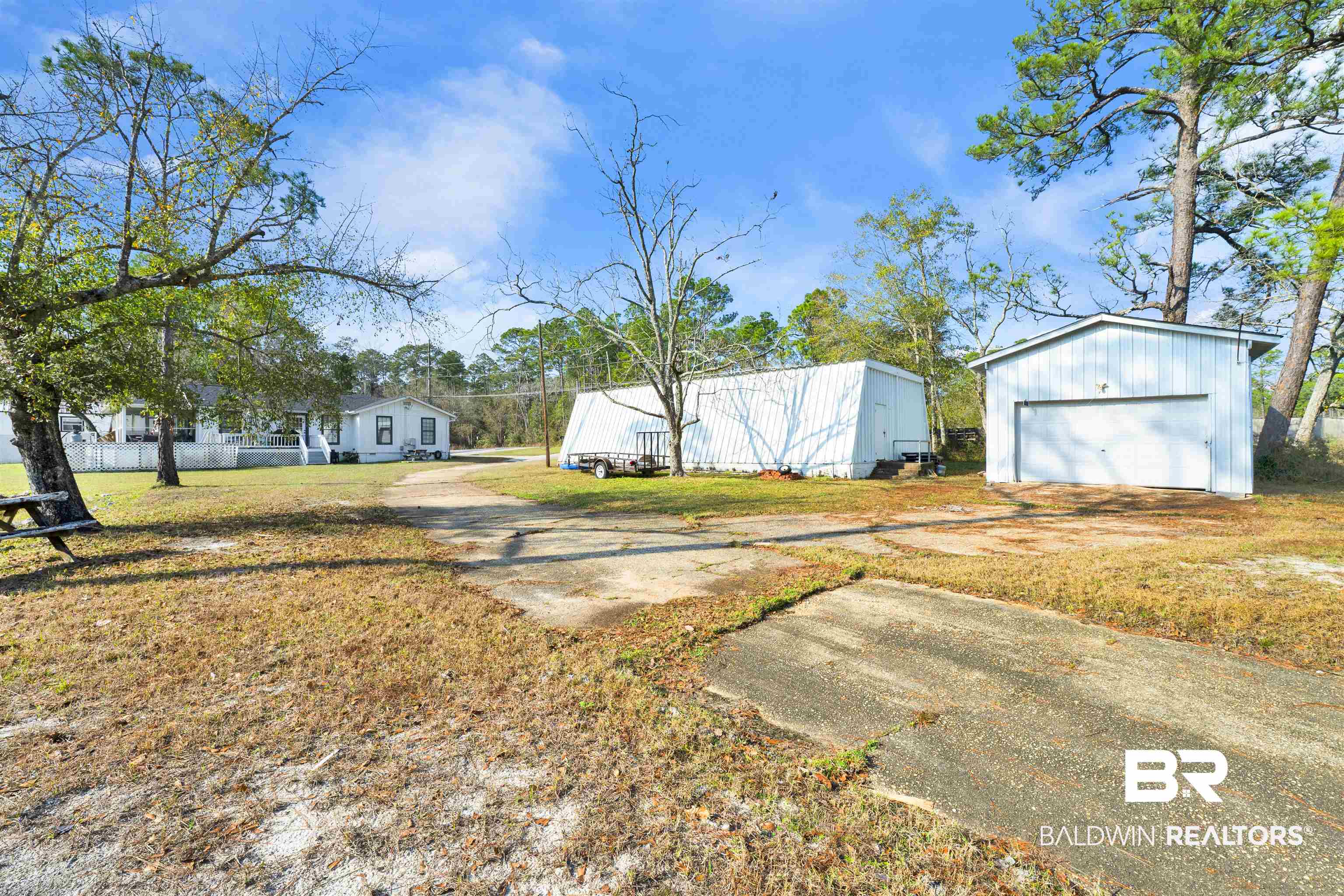 23770 Miflin Road Elberta, AL 36530 - Photo 19 of 38 View of green lawn featuring an outbuilding, a garage, and driveway
