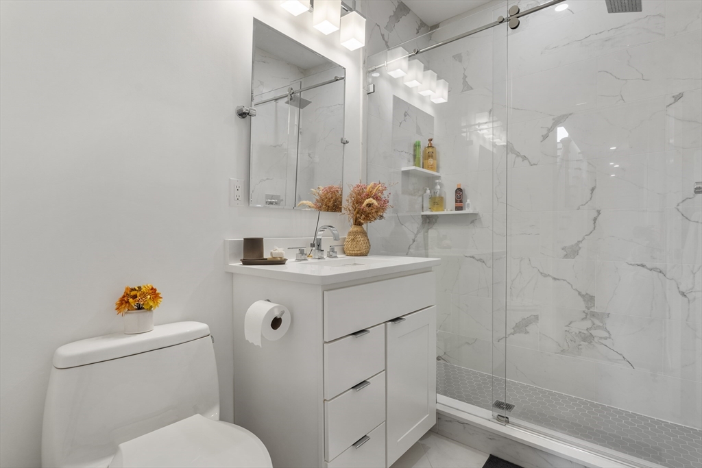 49 Rogers Street, Unit 7 Boston, MA 02127 - Photo 5 of 11 a bathroom with a sink toilet vanity and shower