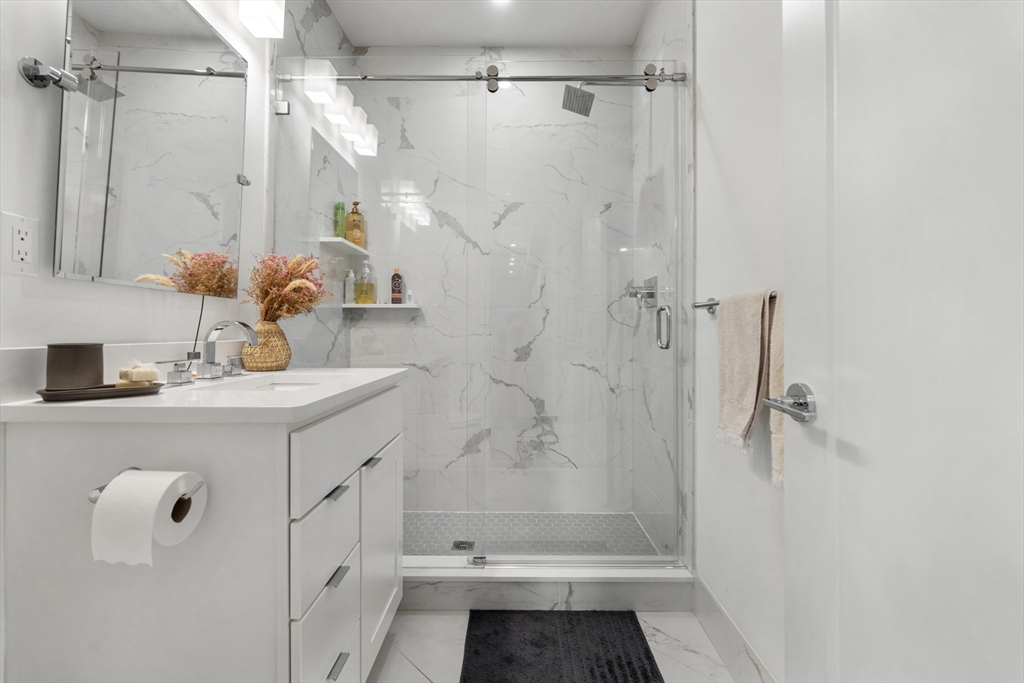 49 Rogers Street, Unit 7 Boston, MA 02127 - Photo 7 of 11 a bathroom with a shower sink and toilet