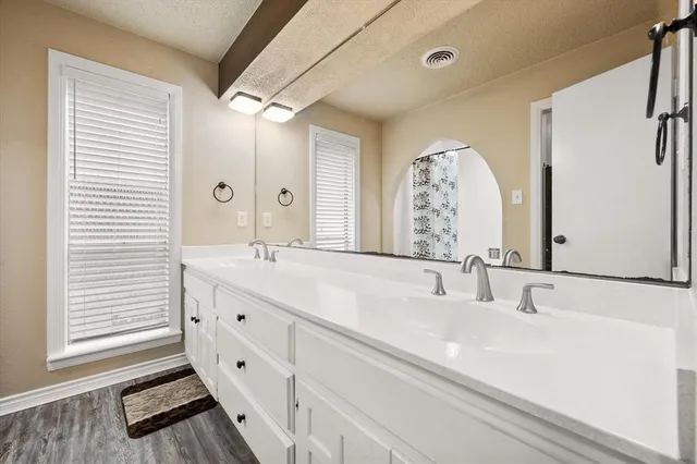 a bathroom with a double vanity sink and a mirror