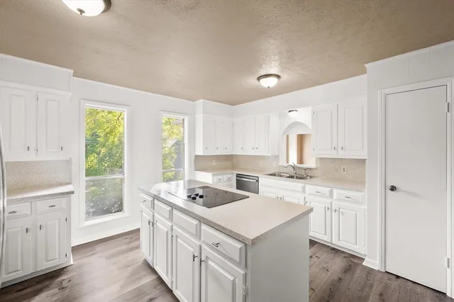 a kitchen with white cabinets and refrigerator