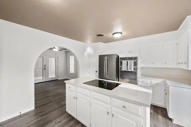 a kitchen with a stove cabinets and wooden floor