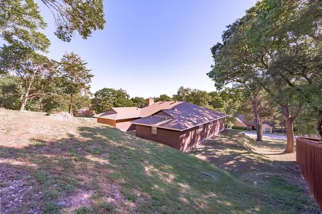 a view of a house with a yard and large tree
