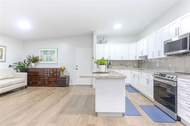 a kitchen with stainless steel appliances granite countertop a stove a sink and a microwave
