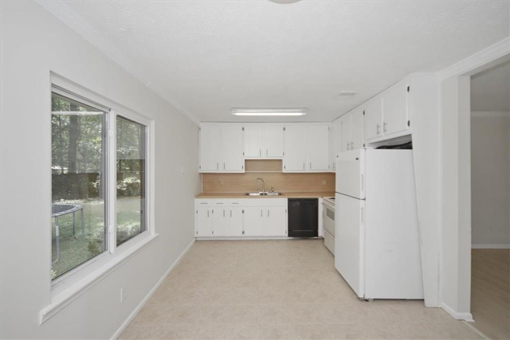 142 Deer Run Canton, GA 30114 - Photo 14 of 24 a kitchen with a refrigerator a stove top oven and a large window