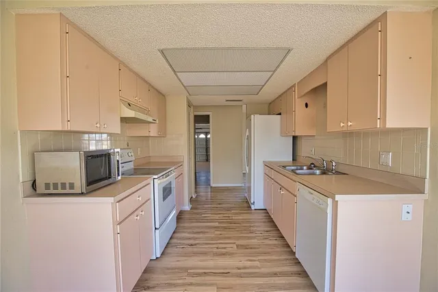 a kitchen with stainless steel appliances a sink stove top oven and cabinets