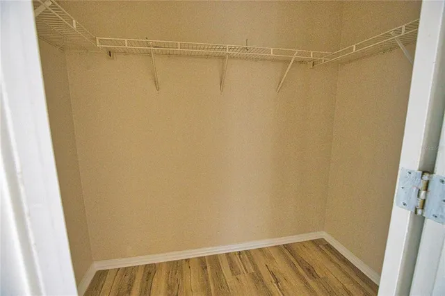 a view of a room with wooden floor and small window