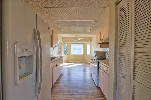 a hallway view with wooden floor and staircase