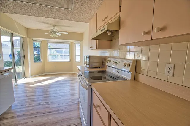 a kitchen with stainless steel appliances granite countertop a sink a stove and wooden floor
